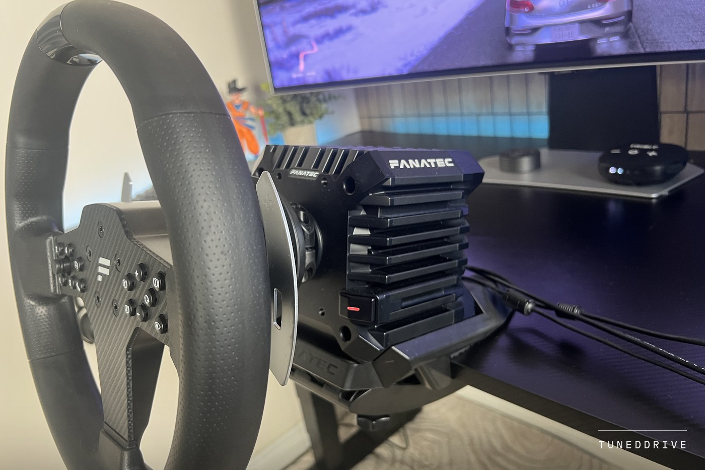 Side view of the P1 V2 wheel attached to the CSL DD base by its quick release, the base's finned body and FANATEC mark behind
