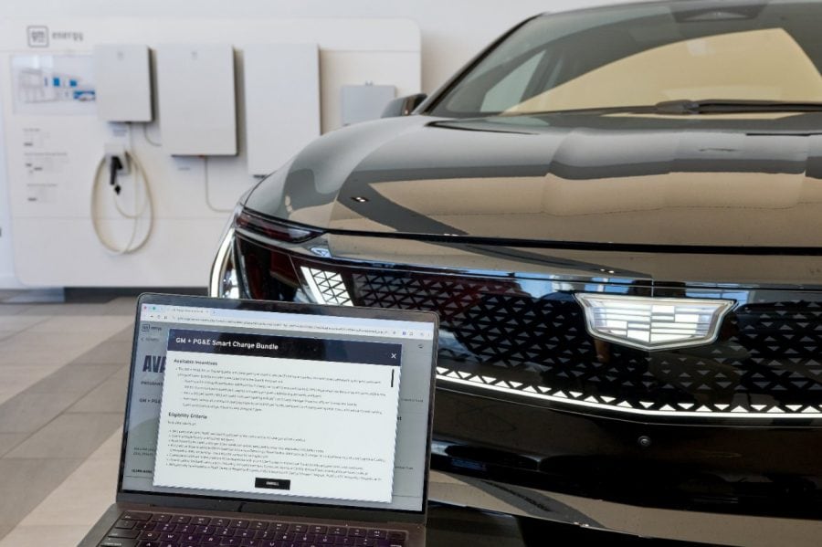 A laptop shows the GM and PG&E Smart Charge Bundle enrollment page in front of a Cadillac.