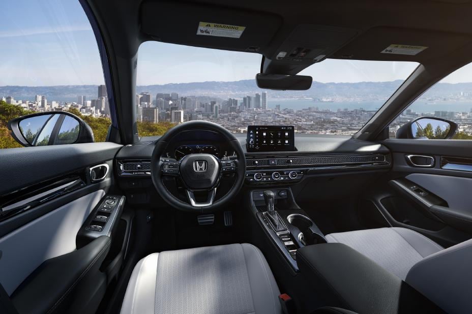 Honda Civic front seats and dashboard with a touchscreen, climate controls and center console.